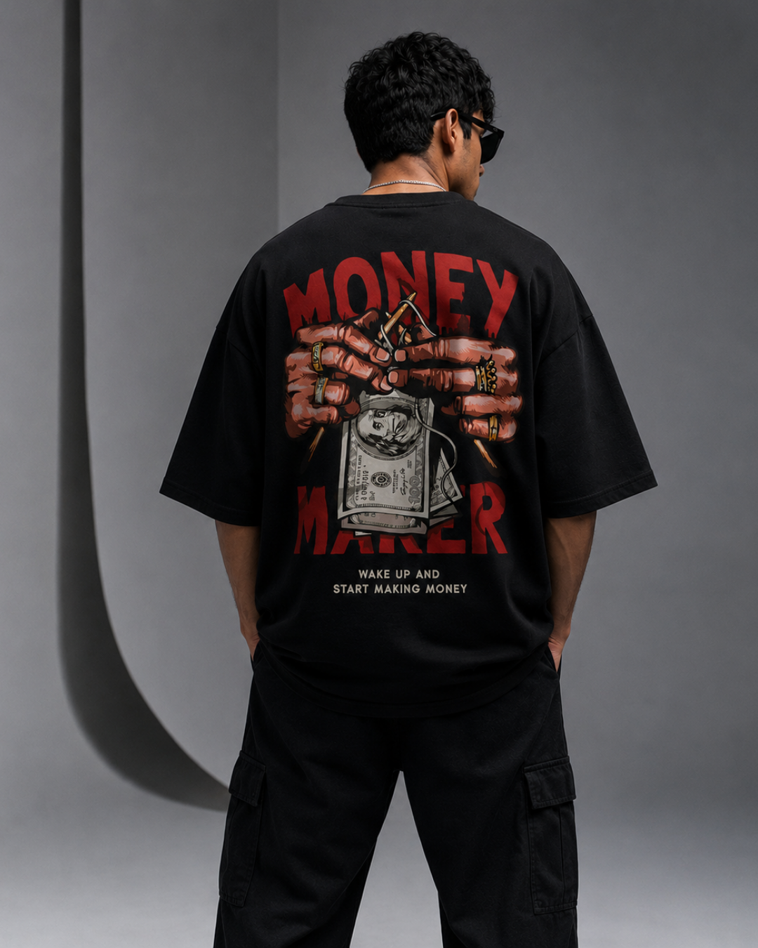 Male model showing back graphic print of Oversoul Money Maker oversized black t-shirt