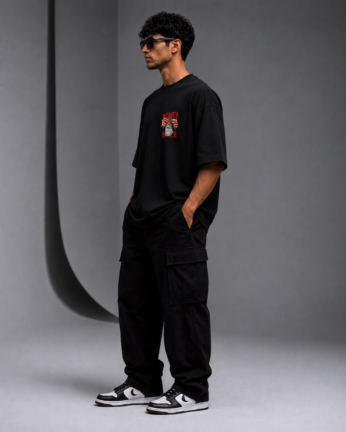 Male model wearing black Oversoul Money Maker Graphic Unisex Oversized T-Shirt side profile view