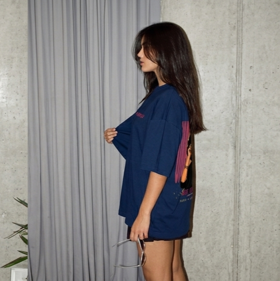 Unbothered Graphic Unisex Oversized T-Shirt in deep navy blue side view on female model